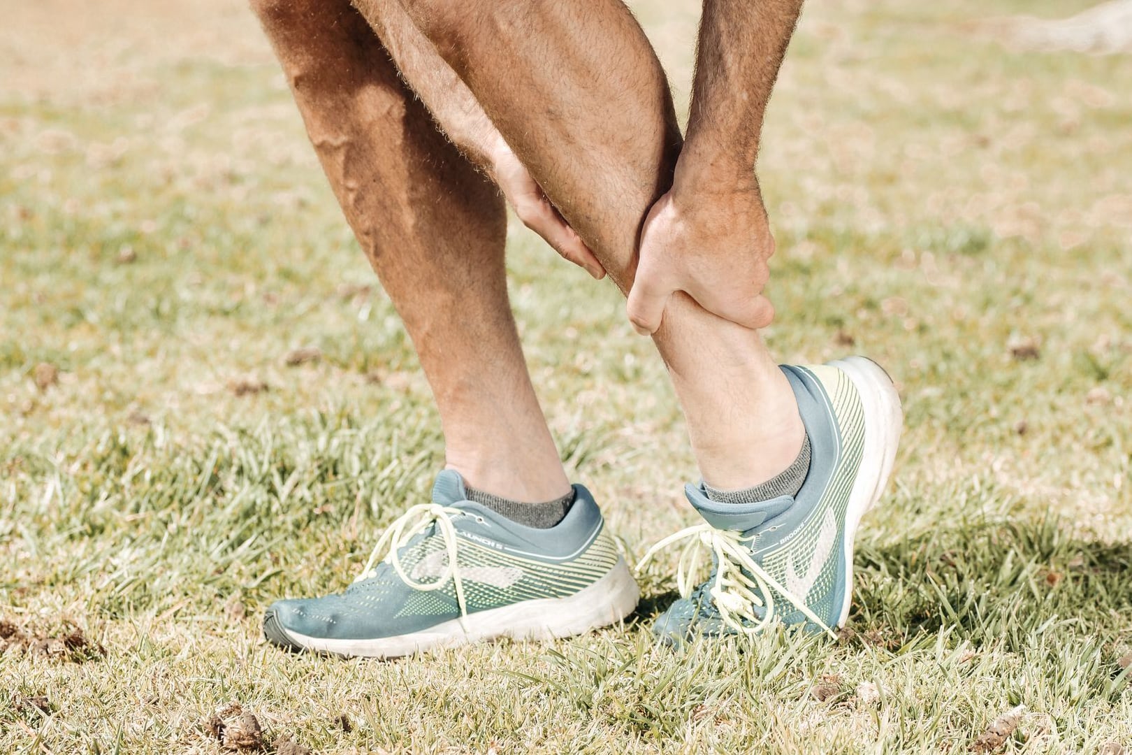 Man massaging his calf outdoors